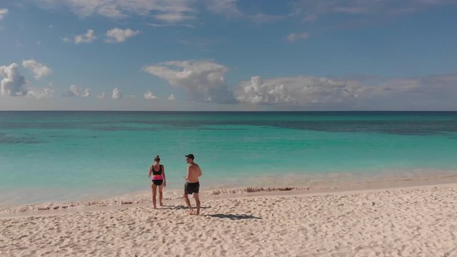 HD drone footage of couple walking on empty beach