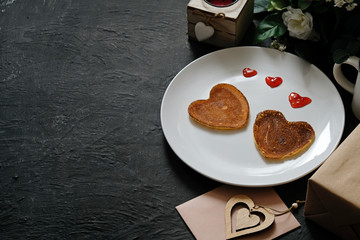 Pancakes heart shaped on white plate, composition for valentines day with food. Space for text