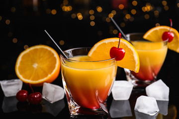 Fresh alcoholic Tequila Sunrise cocktail on black table