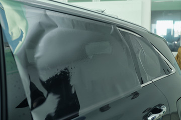 Car window covered with tinting foil, closeup