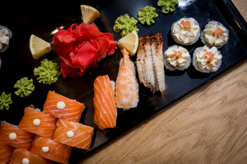 Sushi set. Rolls with salmon, eel and red caviar on a wooden plate. Restaurant.