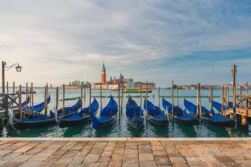 Venice, Italy. Pier with moored gondolas on Saint Mark square with San Giorgio di Maggiore church on background