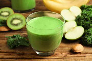 Tasty fresh kale smoothie on wooden table, closeup