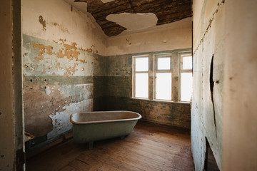 Old bathtube in ruins of Kolmanskop located in the Namib desert near Luderitz