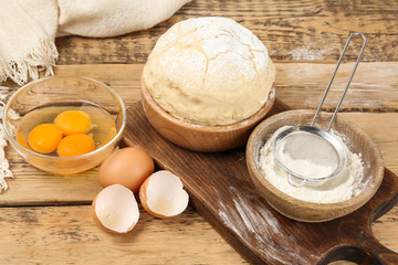 Raw eggs and other ingredients on wooden table. Baking pie