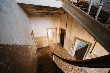 Old staircase in abandoned house filled with sand, Kolmanskop Ghost Town