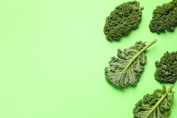 Fresh kale leaves on light green background, flat lay. Space for text