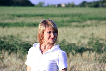 Fototapeta na wymiar Girl in a white jacket on the background of the field