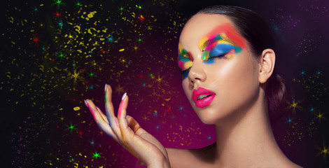 Beautiful girl with festive bright multi-colored make up  on the face. Young woman dressed in...