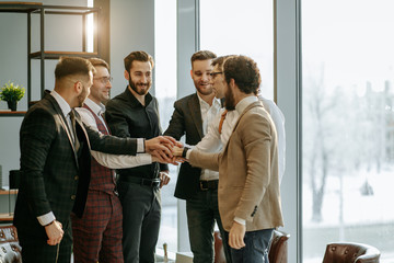 happy business team, business men in tuxedo joined hands in one, success depends on togetherness...