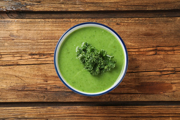 Tasty kale soup on wooden table, top view