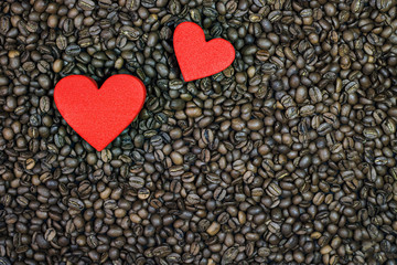 Roasted coffee beans and two red hearts