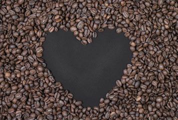Roasted coffee beans and empty space in the shape of a heart