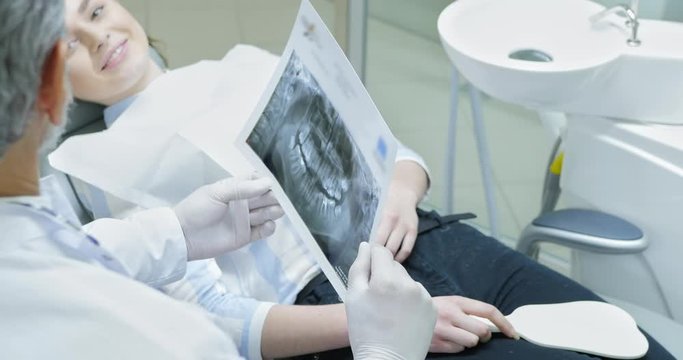 Dentist showing x ray picture to patient.
