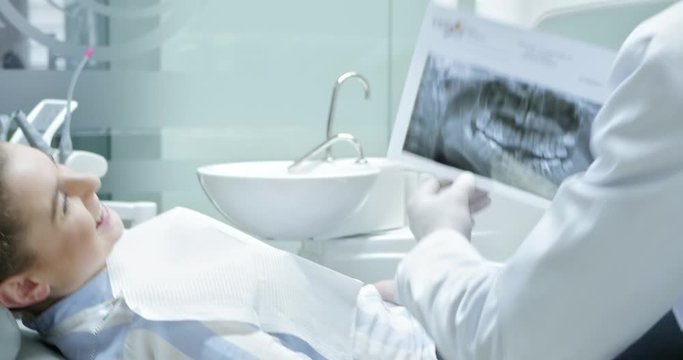 Dentist showing x ray picture to patient.