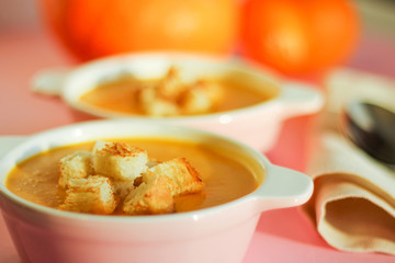 pumpkin soup puree on a pink background