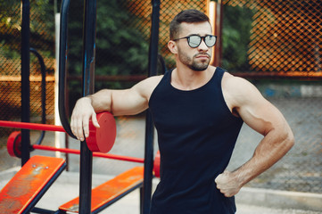 Obraz premium Man training. Guy in a sports shorts. Male in a summer park