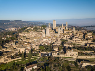 Fototapeta na wymiar Big drone aerial landscape of the wonderful village of San Gimignano a small walled medieval hill town in the province of Siena, Tuscany in morning mystic fog.