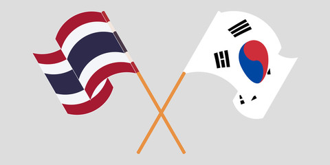 Crossed and waving flags of Thailand and South Korea