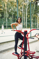 Girl training. Woman in a sports shorts. Brunette in a summer park