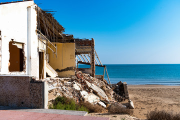 Obraz na płótnie Canvas Building destroyed after storm in the beach