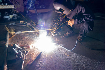 The welder is welding the various parts of the house construction.