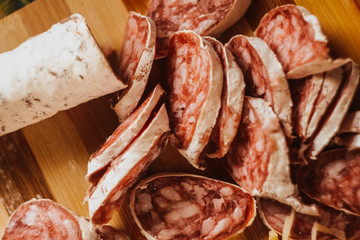 Cutting sausage. Fuet salami on wooden desk