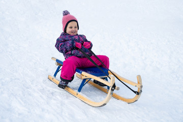 Fototapeta na wymiar Kid Sliding With Sledge In The Snow