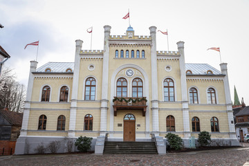 Naklejka premium Government building with red Latvia flags waving on the backgorund of cloudy, overcast day.