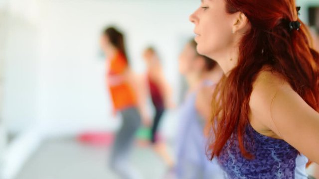 Dance fitness zumba class group of beautiful women dancing enjoying workout practicing choreography moves with instructor in fitness studio, 4k slow motion