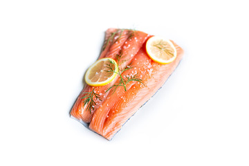 fresh raw salmon with dill, lemon slices and salt isolated on a white background