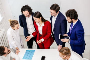 young active colleagues in business office discussing, communicating in office, realizing new business idea and project, wearing formal clothes, tuxedo and blazers