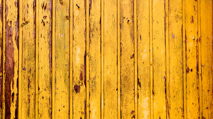 Old yellow wood texture background. painted wooden wall. Yellow background. Bright fence made of...