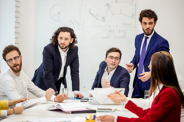 diverse young people in formal wear have conversation, communicate with each other in boardroom, discuss deadline of project and how to reach best results