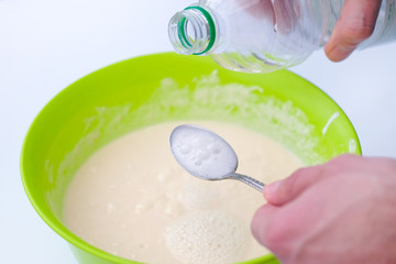 Baking soda is quenched with vinegar. A spoon of soda and a plastic bottle. The process of making...