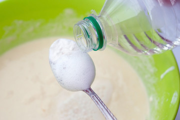 Baking soda is quenched with vinegar. A spoon of soda and a plastic bottle. The process of making...