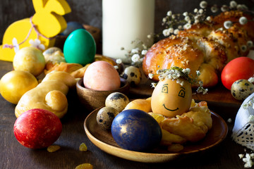 Easter pastries background. Colored eggs on a wooden table.