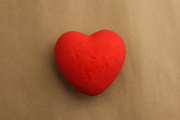Red heart on brown paper background