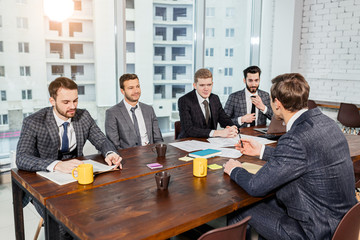 teamwork of caucasian business men in tuxedo gathering for discussion, debate and explaining. planning and developing strategies for future work with business partners