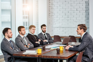 young caucasian manager or boss in tux talk with co-workers, business coworking of stylish elegant...