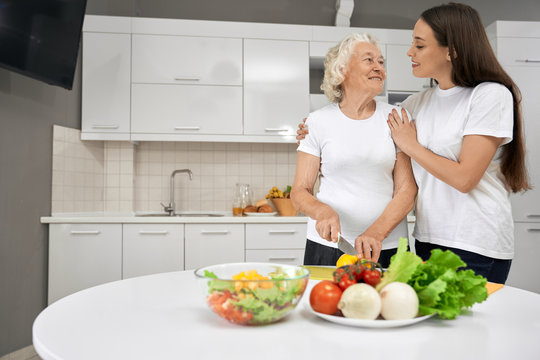 Happy Grandmother And Granddaughter Cooking Together.