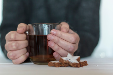 Woman warming her hands with hot cup of tea