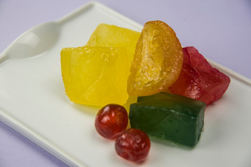 candied orange and others fruits on white tray and bright background