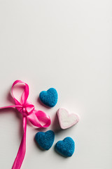 Marmalade in sugar blue, and marshmallows in the form of hearts with bow on white background