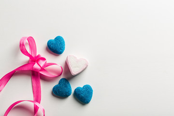 Marmalade in sugar blue, and marshmallows in the form of hearts with bow on white background