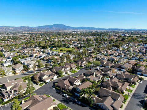 Aerial View Of Residential Suburban Packed Homes Neighborhood During Blue Sky Day In Irvine, Orange County, USA