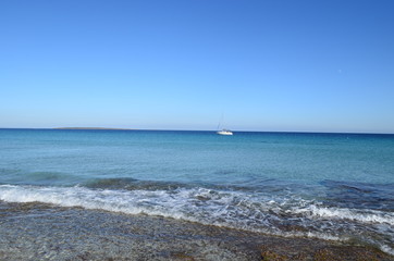 Fototapeta na wymiar velero blsanco en las tranquilas aguas del mar mediterraneo en ibiza