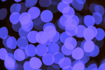 Abstract blue blurred lights background. Festive blue defocused blinking lights on black background