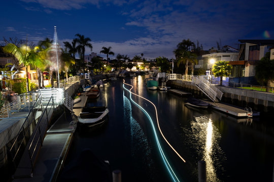 Light trails from two boats as they pass each other at night on the Rivo Alto Canal on Naples Island in Long Beach, Calif.