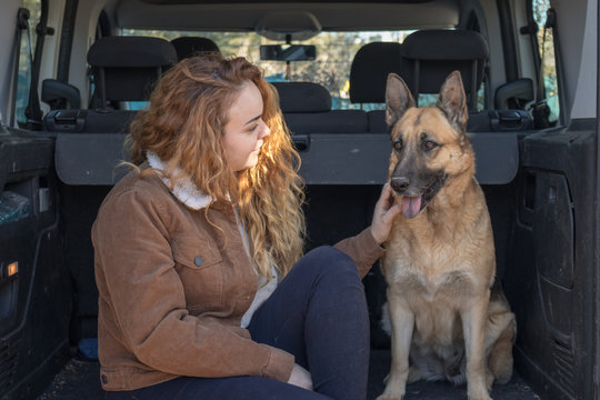 Mujer con su perro pastor alem&aacute;n prepar&aacute;ndose para un viaje en furgoneta 
